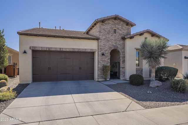 view of front of property with a tile roof, brick siding, stucco siding, concrete driveway, and an attached garage