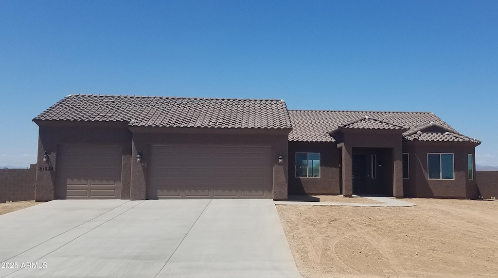300 W Quartz Rock Rd, Phoenix, AZ 85085 - view of front facade with an attached garage, driveway, stucco siding, and a tiled roof
