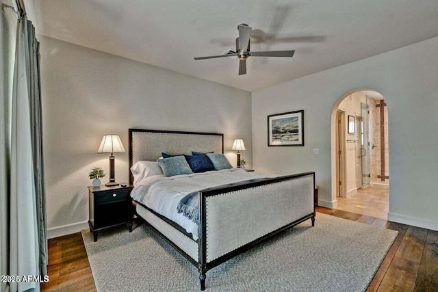 3935 E Rough Rider Rd Unit 1360, Phoenix, AZ 85050 - bedroom with arched walkways, hardwood / wood-style flooring, baseboards, and a ceiling fan