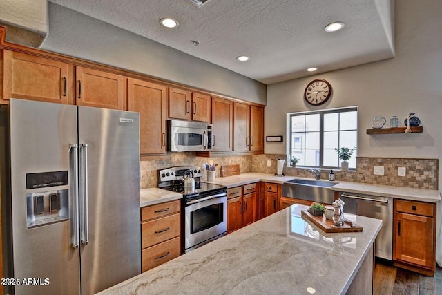 3935 E Rough Rider Rd Unit 1360, Phoenix, AZ 85050 - kitchen with stainless steel appliances, a sink, light stone countertops, brown cabinets, and recessed lighting