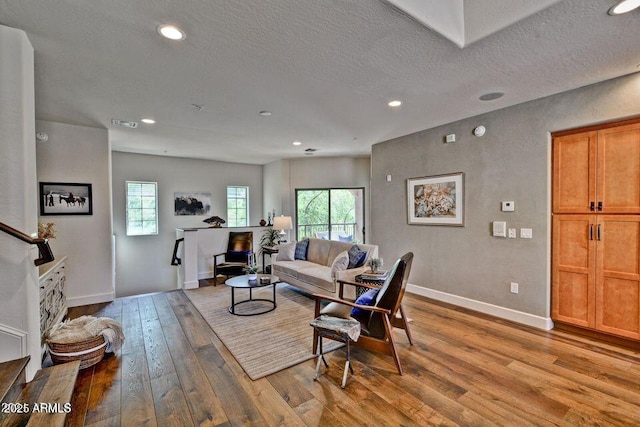 3935 E Rough Rider Rd Unit 1360, Phoenix, AZ 85050 - living room with wood-type flooring, baseboards, healthy amount of natural light, recessed lighting, and a textured ceiling