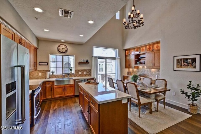 3935 E Rough Rider Rd Unit 1360, Phoenix, AZ 85050 - kitchen featuring stainless steel appliances, open shelves, brown cabinets, dark wood-style flooring, and a kitchen island