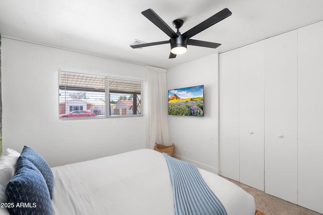 carpeted bedroom featuring ceiling fan and a closet