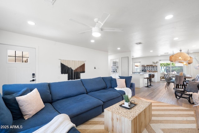 living room featuring ceiling fan and light hardwood / wood-style flooring