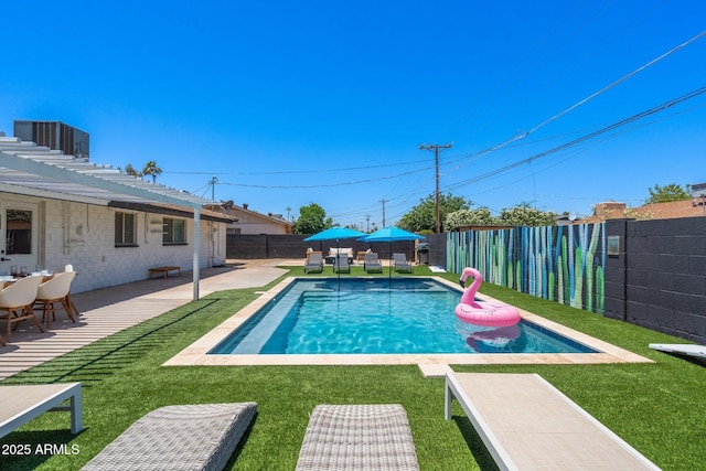 view of pool with a lawn and a patio