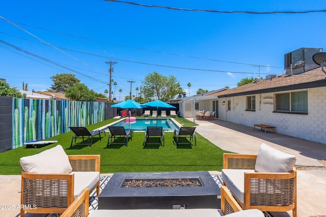 view of yard featuring a fenced in pool, a patio area, and a fire pit