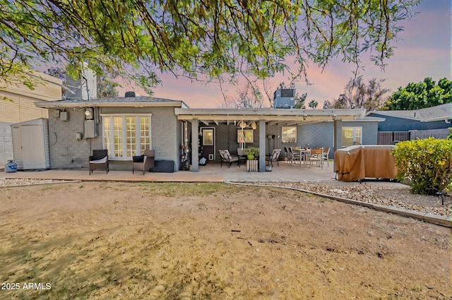 1712 E Montebello Ave, Phoenix, AZ 85016 - back of house at dusk featuring a patio area, a chimney, and concrete block siding