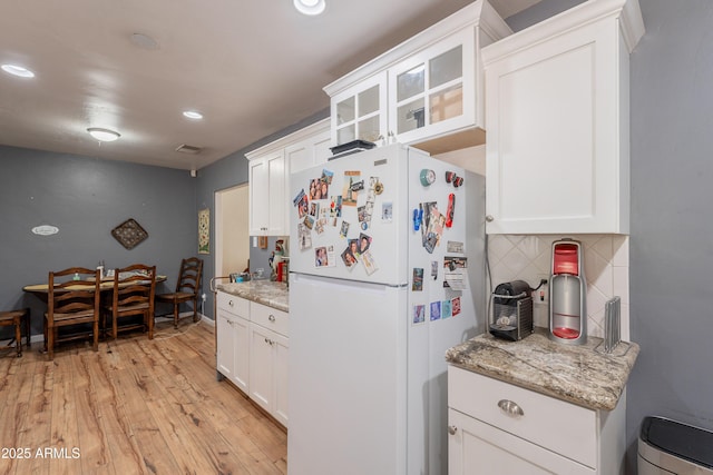 1712 E Montebello Ave, Phoenix, AZ 85016 - kitchen with freestanding refrigerator, light wood-type flooring, backsplash, white cabinetry, and recessed lighting