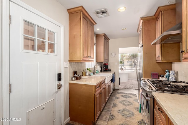 4832 E Cambridge Ave, Phoenix, AZ 85008 - kitchen with stainless steel range with gas cooktop, wall chimney exhaust hood, a sink, brown cabinets, and recessed lighting