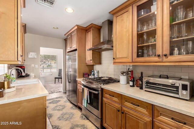 4832 E Cambridge Ave, Phoenix, AZ 85008 - kitchen with stainless steel appliances, wall chimney range hood, a sink, tasteful backsplash, and brown cabinetry