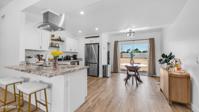 1717 W Roma Ave, Phoenix, AZ 85015 - kitchen featuring freestanding refrigerator, wall chimney range hood, open shelves, a peninsula, and white cabinets