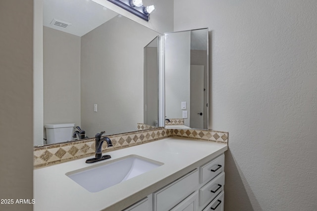4165 E Huntington Dr, Phoenix, AZ 85040 - bathroom with tasteful backsplash, vanity, a textured wall, toilet, and visible vents