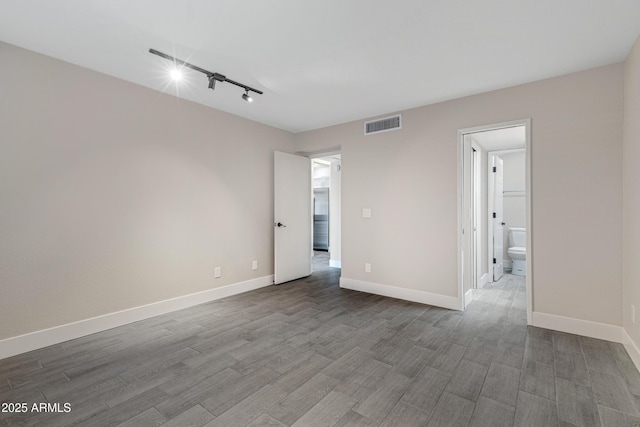 4165 E Huntington Dr, Phoenix, AZ 85040 - unfurnished room featuring track lighting, wood finished floors, baseboards, and visible vents