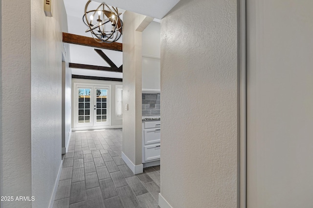 4165 E Huntington Dr, Phoenix, AZ 85040 - corridor featuring beamed ceiling, a textured wall, wood finish floors, and a notable chandelier