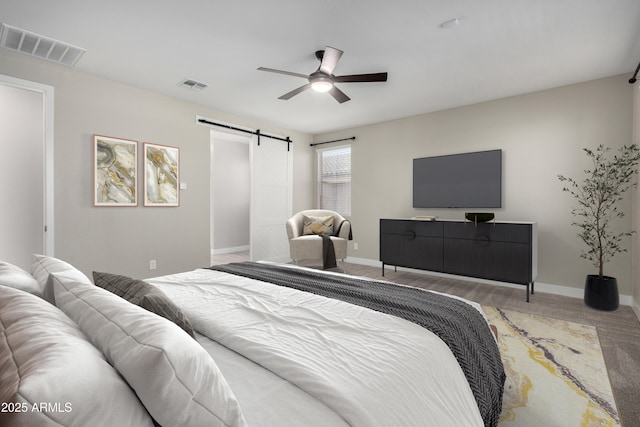 bedroom featuring ceiling fan and a barn door