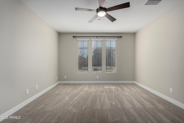 carpeted spare room featuring ceiling fan