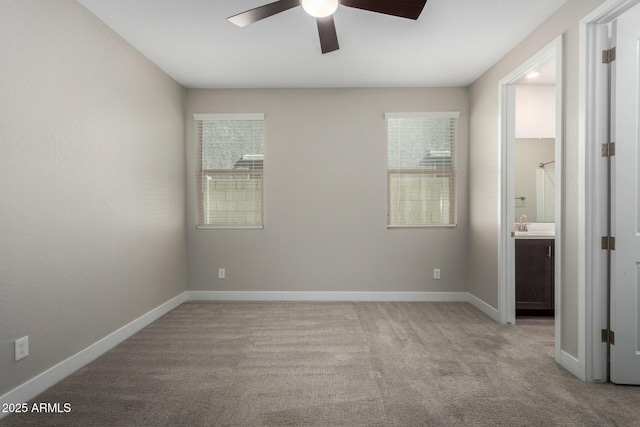 spare room featuring light carpet and ceiling fan