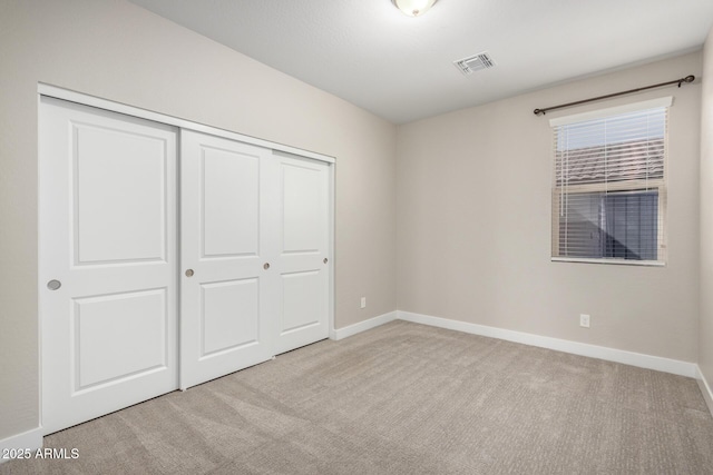 unfurnished bedroom featuring a closet and light carpet