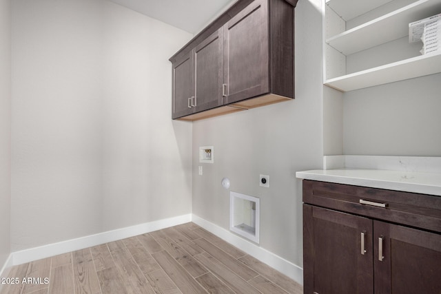 washroom with cabinets, hookup for an electric dryer, hookup for a washing machine, and light hardwood / wood-style flooring