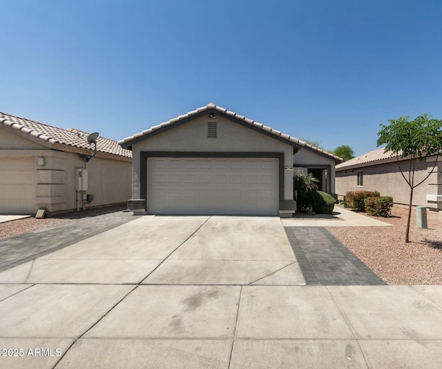 ranch-style home featuring a tiled roof, stucco siding, a garage, and concrete driveway