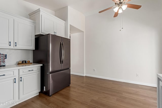 kitchen featuring freestanding refrigerator, ceiling fan, white cabinetry, wood finished floors, and light countertops