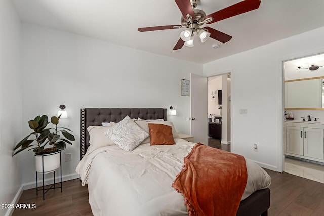 bedroom featuring baseboards, a sink, a ceiling fan, connected bathroom, and wood finished floors