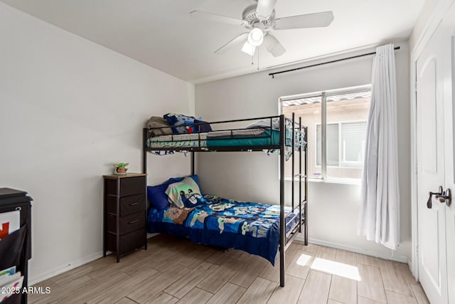 bedroom with baseboards, ceiling fan, and wood tiled floor