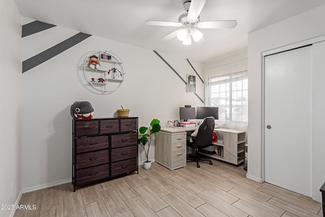 home office with light wood-style flooring, baseboards, and a ceiling fan