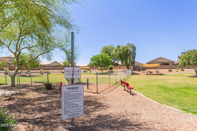 view of community featuring a yard and fence