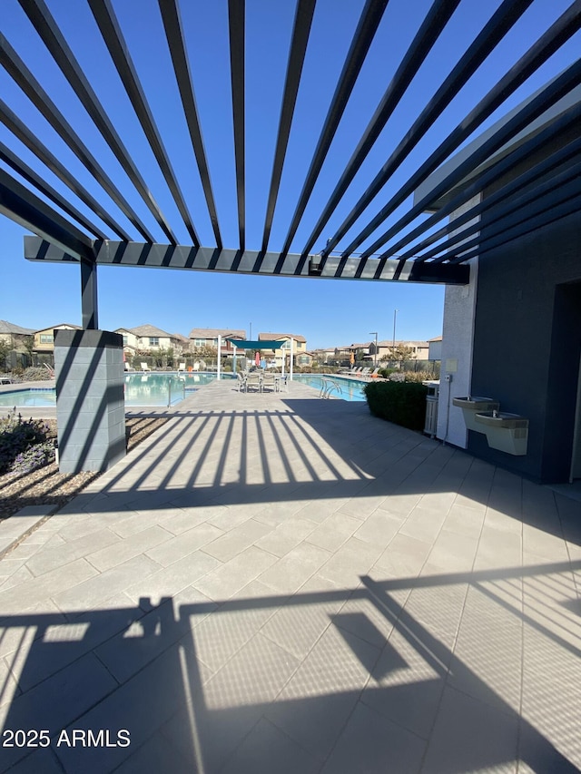 view of patio with a community pool and a pergola