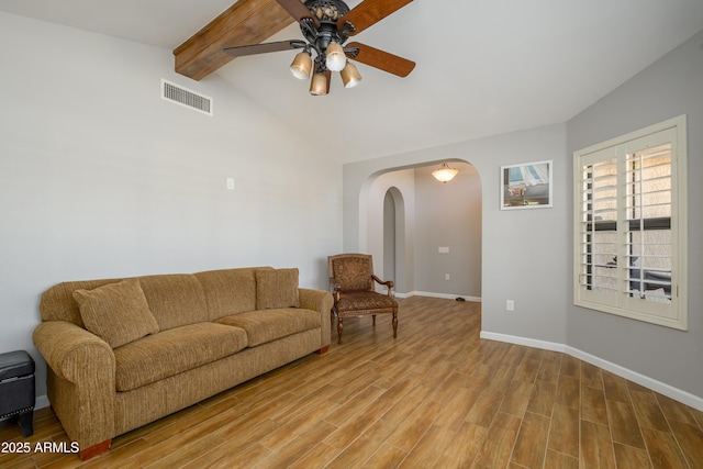 living area featuring ceiling fan, lofted ceiling with beams, light wood finished floors, arched walkways, and visible vents
