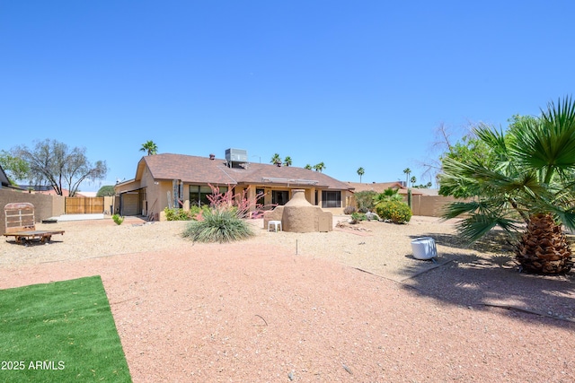 back of house featuring central air condition unit, stucco siding, and fence private yard