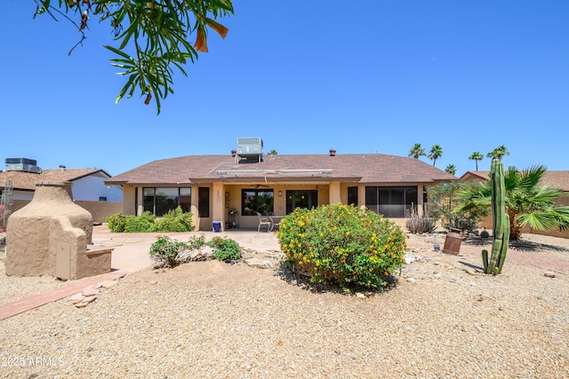 rear view of house with a patio, central AC unit, and stucco siding