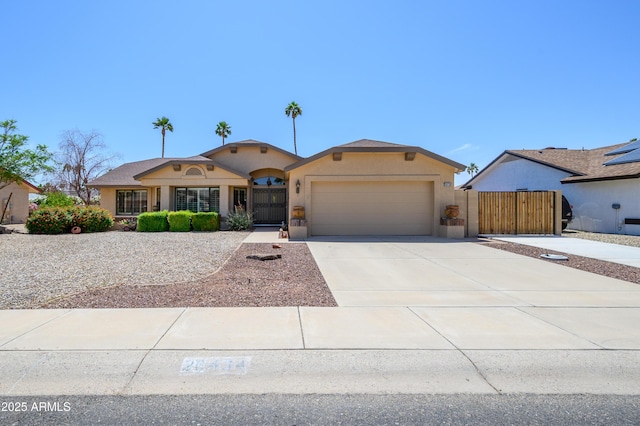ranch-style house with a garage, stucco siding, a gate, and concrete driveway