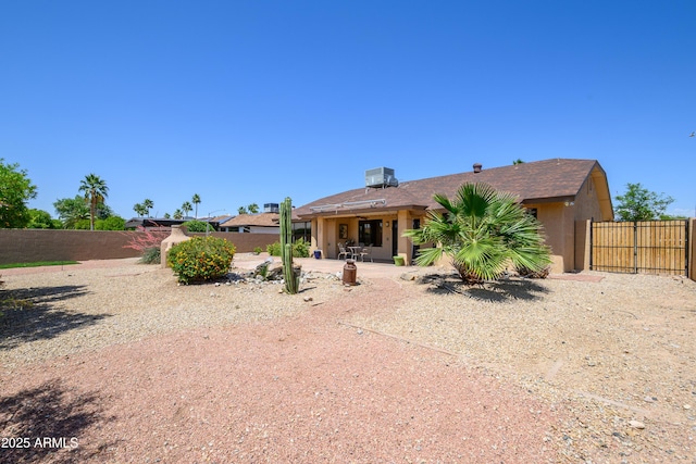 rear view of property with a fenced backyard and a patio