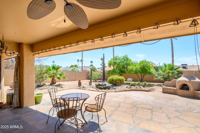 view of patio featuring outdoor dining area, exterior fireplace, and a fenced backyard