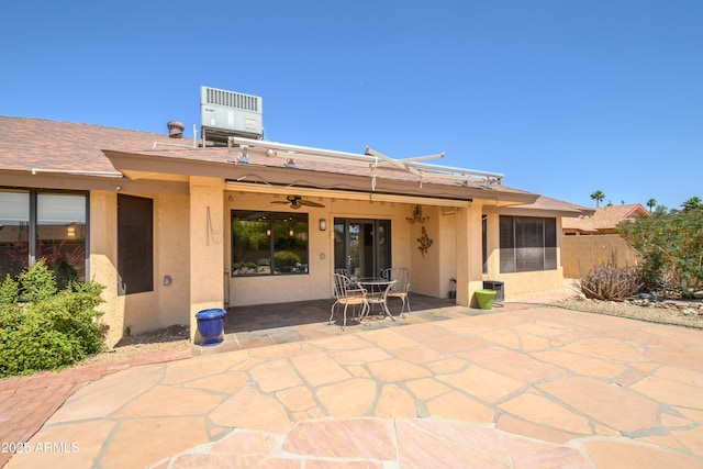 back of property with ceiling fan, central AC, fence, a patio, and stucco siding