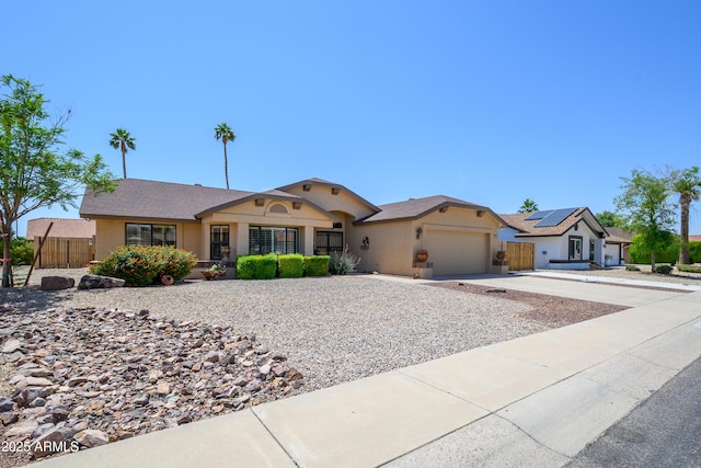ranch-style home featuring fence, an attached garage, driveway, and stucco siding