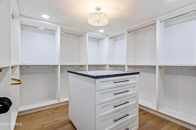 walk in closet featuring a notable chandelier and light wood-type flooring