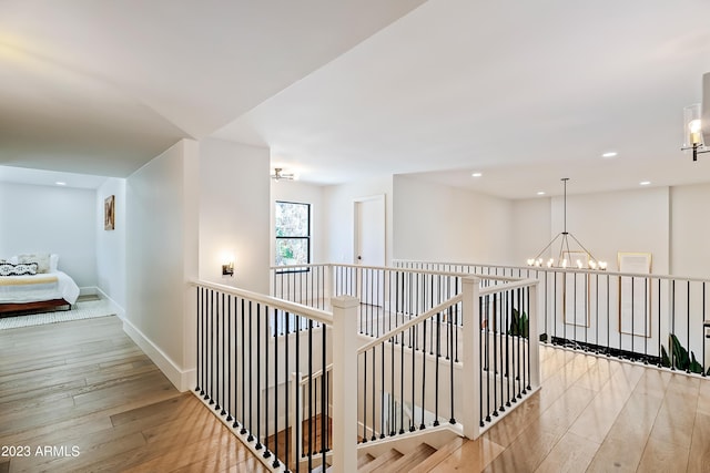 hallway with a chandelier and light hardwood / wood-style floors