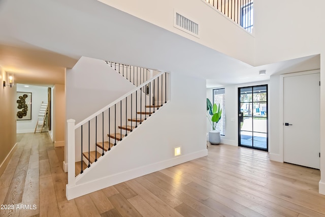 interior space featuring wood-type flooring and a towering ceiling