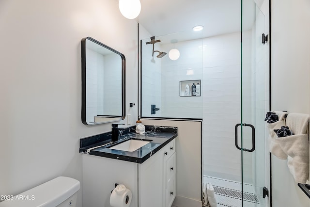 bathroom with vanity, a shower with shower door, and toilet