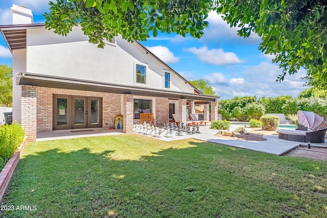 back of house with a lawn, french doors, and a patio