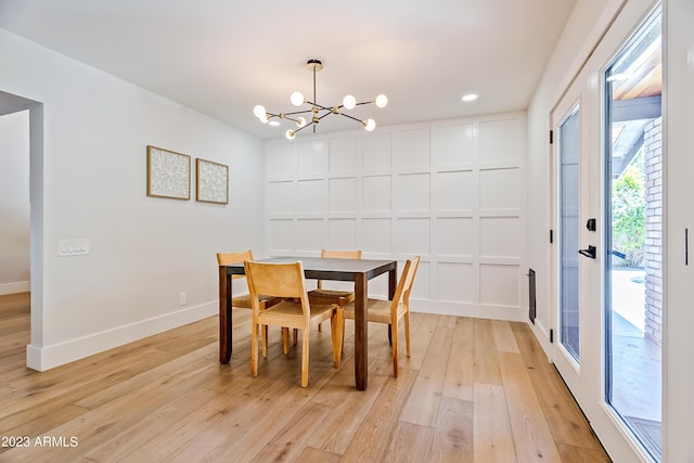 dining area featuring light wood-type flooring and an inviting chandelier