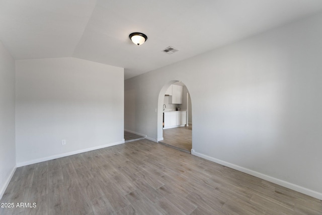 4207 W Culver St, Phoenix, AZ 85009 - unfurnished room with arched walkways, light wood-type flooring, vaulted ceiling, and baseboards