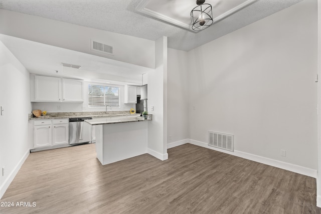 kitchen featuring white cabinets, kitchen peninsula, light wood-type flooring, a textured ceiling, and stainless steel dishwasher