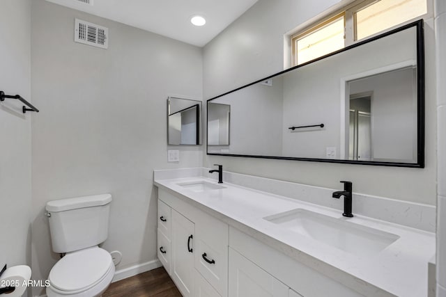 bathroom featuring vanity, hardwood / wood-style flooring, and toilet