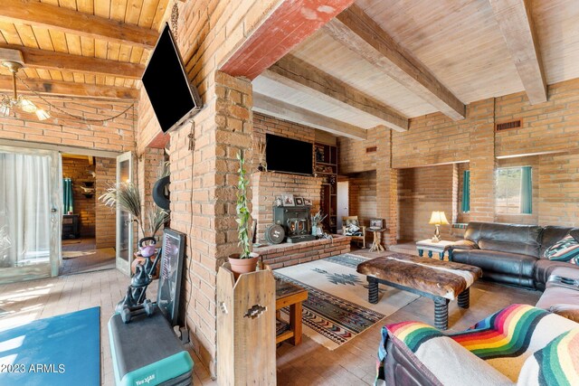 living room featuring wooden ceiling, wood-type flooring, brick wall, and a wood stove