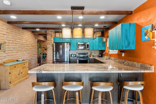 kitchen with pendant lighting, stainless steel appliances, light stone counters, kitchen peninsula, and sink