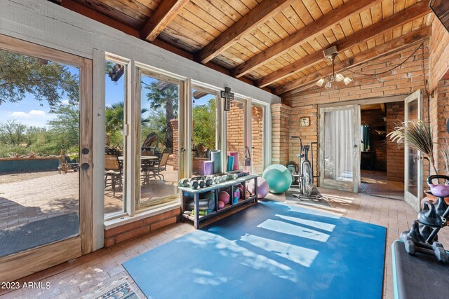 unfurnished sunroom with vaulted ceiling with beams, an inviting chandelier, wooden ceiling, and french doors